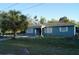 Exterior view of a home with a mature palm tree, fenced yard, and a well-maintained lawn at 3421 E Powhatan Ave, Tampa, FL 33610