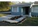 Charming single-story home with a well-manicured front yard and a quaint flower bed leading to the entrance at 3421 E Powhatan Ave, Tampa, FL 33610