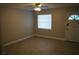 Living room featuring neutral tile floors, a ceiling fan and a front entry door at 3421 E Powhatan Ave, Tampa, FL 33610
