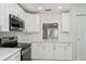 Bright kitchen featuring stainless steel appliances and white cabinets at 406 S Pebble Beach Blvd, Sun City Center, FL 33573