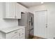 Kitchen featuring stainless steel refrigerator and white cabinets at 406 S Pebble Beach Blvd, Sun City Center, FL 33573