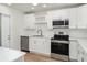 Modern kitchen with stainless steel appliances, white cabinets and countertops at 406 S Pebble Beach Blvd, Sun City Center, FL 33573