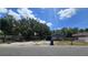 Modest single-Gathering home featuring wood siding and a spacious front yard under a bright blue sky at 4207 E Henry Ave, Tampa, FL 33610
