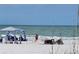 People relaxing on a sunny beach with umbrellas and chairs, enjoying the ocean view on a clear day at 504 67Th Ave # 4, St Pete Beach, FL 33706