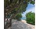 Sandy beach view with lush greenery and clear blue water in the background at 504 67Th Ave # 4, St Pete Beach, FL 33706