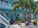 Charming teal apartment building with palm trees, green chairs, and a community grill area at 504 67Th Ave # 4, St Pete Beach, FL 33706