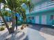 Inviting teal apartment complex featuring tropical landscaping, painted doors, and communal outdoor seating at 504 67Th Ave # 4, St Pete Beach, FL 33706