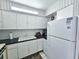Efficient kitchen with white appliances, laminate countertops, and ample cabinet space at 504 67Th Ave # 4, St Pete Beach, FL 33706