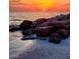 Beautiful sunset view over the beach and ocean with rocks in the foreground at 504 67Th Ave # 4, St Pete Beach, FL 33706