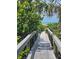 Scenic boardwalk through lush greenery leads to the beach and ocean, offering a tranquil path at 504 67Th Ave # 4, St Pete Beach, FL 33706