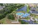 Scenic aerial view of a community pool, clubhouse, and tranquil lake surrounded by lush trees at 5416 Camberwell Ln, Riverview, FL 33578