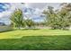 Expansive backyard featuring a well-manicured lawn, a privacy fence, and mature trees providing shade at 5416 Camberwell Ln, Riverview, FL 33578