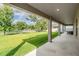 Covered back patio overlooking a spacious, well-maintained backyard with a scenic lake view at 5416 Camberwell Ln, Riverview, FL 33578