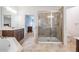 Bright bathroom featuring a glass-enclosed shower, soaking tub, double sink vanity, and tiled flooring at 5416 Camberwell Ln, Riverview, FL 33578
