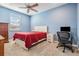 Well-lit bedroom featuring blue walls, neutral carpet, ceiling fan, and a cozy red quilted bedspread at 5416 Camberwell Ln, Riverview, FL 33578