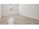 Empty bedroom with neutral color scheme, featuring light tile floors and a bright window at 5416 Camberwell Ln, Riverview, FL 33578