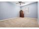 Carpeted bedroom featuring neutral tones, a ceiling fan, and a wooden dresser illuminated by natural light at 5416 Camberwell Ln, Riverview, FL 33578