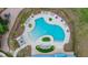 Drone image of pool with unique design, lounge area, play area, set in lush landscape with chairs and tables at 5416 Camberwell Ln, Riverview, FL 33578