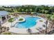 Resort-style community pool with a unique design, ample lounge seating, and lush landscaping at 5416 Camberwell Ln, Riverview, FL 33578
