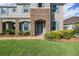Close-up of a two-story home's stone accented entrance, blue shutters and manicured lawn at 5416 Camberwell Ln, Riverview, FL 33578