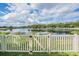 Scenic lake view framed by a white picket fence, offering a serene and picturesque backyard setting at 5416 Camberwell Ln, Riverview, FL 33578
