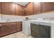 Convenient laundry room featuring washer, dryer, sink, and ample storage cabinets for streamlined efficiency at 5416 Camberwell Ln, Riverview, FL 33578