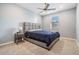 Stylish main bedroom featuring a gray platform bed, blue bedding, and a mid-century modern side table at 5416 Camberwell Ln, Riverview, FL 33578
