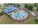 Aerial view of a community pool with lounge chairs, tables, a playground, and clubhouse at 5416 Camberwell Ln, Riverview, FL 33578
