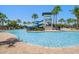 Community pool with water slide and tower, surrounded by palm trees and lounge chairs, perfect for relaxation at 5547 Silver Sun Dr, Apollo Beach, FL 33572