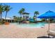 Community pool with water slide and tower, surrounded by palm trees and lounge chairs, perfect for relaxation at 5547 Silver Sun Dr, Apollo Beach, FL 33572
