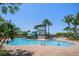 Community pool with water slide and tower, surrounded by palm trees and lounge chairs, perfect for relaxation at 5547 Silver Sun Dr, Apollo Beach, FL 33572