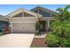 Beautiful one-story home with a two-car garage, stone accents, and mature tropical landscaping at 5547 Silver Sun Dr, Apollo Beach, FL 33572