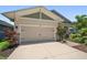 Exterior view showcasing a home's two-car garage with lush landscaping and stone accents at 5547 Silver Sun Dr, Apollo Beach, FL 33572