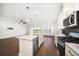 Modern kitchen with stainless steel appliances, island with sink, pendant lighting, and hardwood floors at 5547 Silver Sun Dr, Apollo Beach, FL 33572