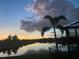 Beautiful lake view featuring a palm tree and sunset sky, creating a serene and picturesque setting at 5547 Silver Sun Dr, Apollo Beach, FL 33572