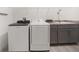 Functional laundry room equipped with modern washer, dryer, sink, and ample counter space at 5547 Silver Sun Dr, Apollo Beach, FL 33572