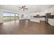 Open-concept living room featuring wood floors, ceiling fan, and large sliding doors with a lake view at 5547 Silver Sun Dr, Apollo Beach, FL 33572