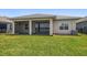 Screened-in back patio with views of the manicured lawn and tranquil lake at 5547 Silver Sun Dr, Apollo Beach, FL 33572