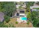 An aerial view reveals a home with an in-ground pool, solar panels, brick patio, and lush landscaping at 5761 Colonial Dr, New Port Richey, FL 34653