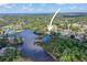 A high aerial view of a home and lot located on a body of water surrounded by other houses and natural areas at 5761 Colonial Dr, New Port Richey, FL 34653