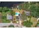 Aerial view of home with a private pool, boat dock, solar panels and spacious, wooded lot near a body of water at 5761 Colonial Dr, New Port Richey, FL 34653