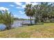 Enjoy the serene waterfront view from the lush backyard with mature trees and tropical foliage at 5761 Colonial Dr, New Port Richey, FL 34653