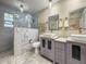 Stylish bathroom with double vanity, modern fixtures, and a tiled walk-in shower at 5761 Colonial Dr, New Port Richey, FL 34653