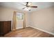Bedroom featuring hardwood floors, a ceiling fan, a dresser, and a window with natural light at 5761 Colonial Dr, New Port Richey, FL 34653