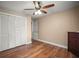 Bedroom with hardwood floors, ceiling fan, closet, dresser, and neutral paint at 5761 Colonial Dr, New Port Richey, FL 34653