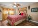 Comfortable bedroom with hardwood floors, ceiling fan, and decorative curtains at 5761 Colonial Dr, New Port Richey, FL 34653