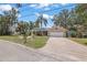Inviting single-story home with a brick driveway, mature trees, and well-kept landscaping at 5761 Colonial Dr, New Port Richey, FL 34653