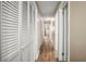 Hallway featuring hardwood floors, multiple closets with white doors, and neutral paint at 5761 Colonial Dr, New Port Richey, FL 34653