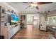 Bright living room with hardwood floors, white trim, entertainment center, and relaxing recliner at 5761 Colonial Dr, New Port Richey, FL 34653