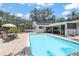 Relax by the refreshing in-ground pool on a sunny day with solar panels overhead at 5761 Colonial Dr, New Port Richey, FL 34653